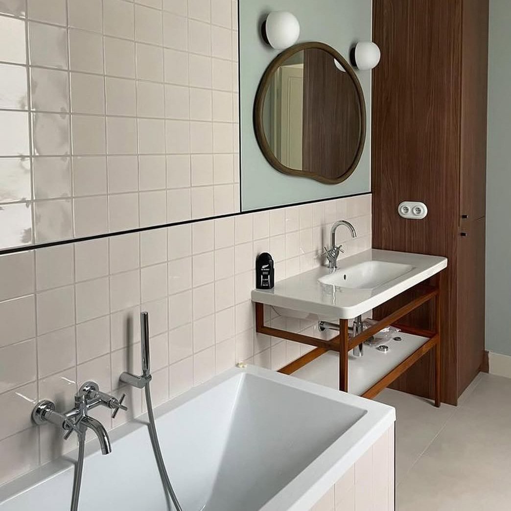 Salle de bain rénovée avec un carrelage moderne, murs et sol habillés de carreaux.