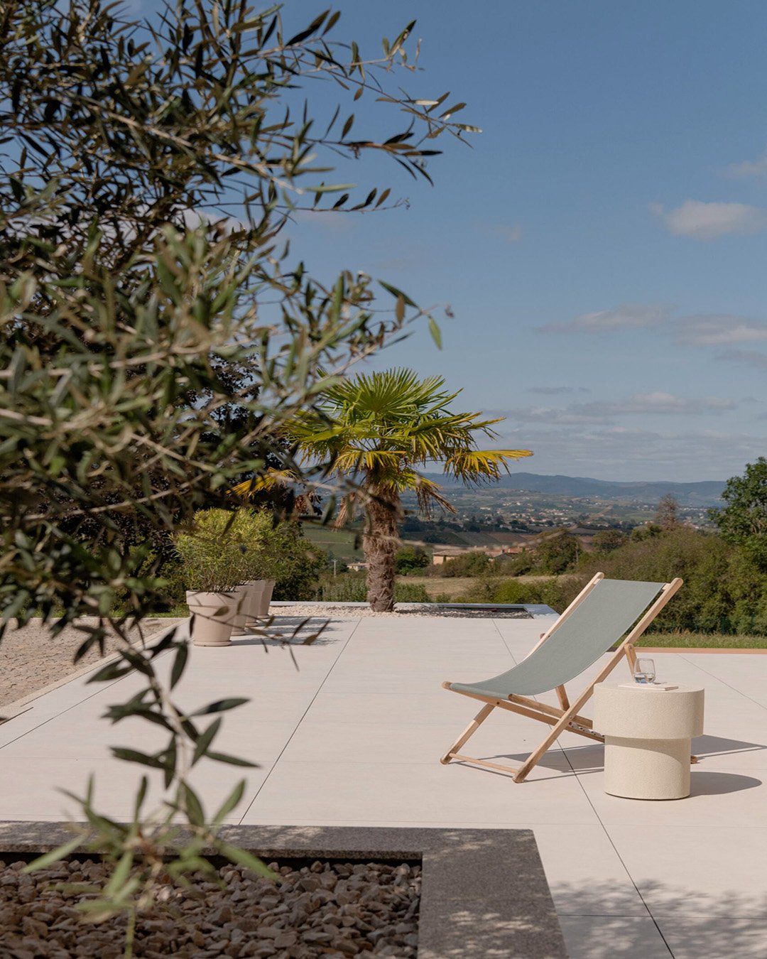 Terrasse en dalles autour d’une piscine de villa dans le Beaujolais